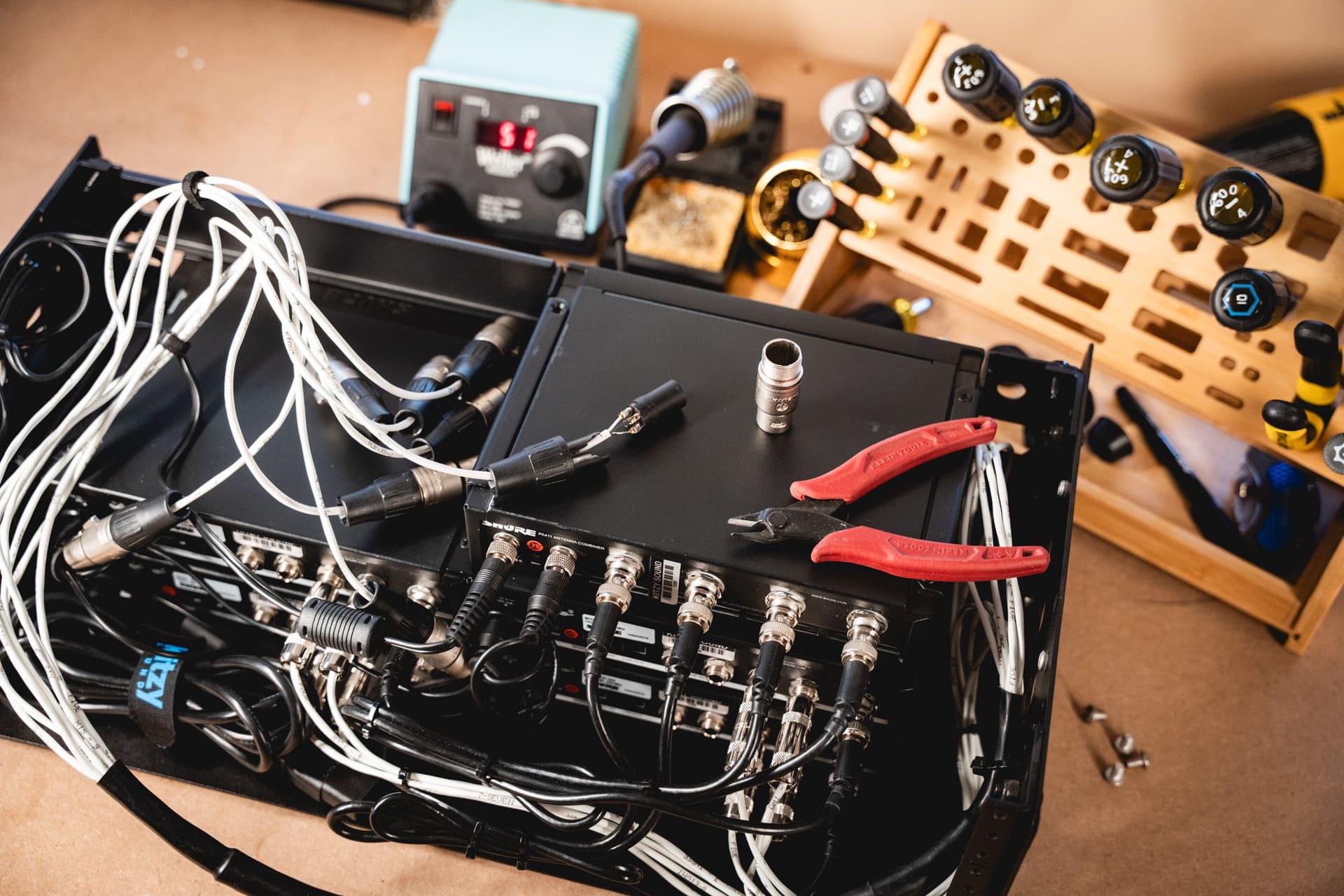 Custom rig wiring on the build bench with soldering station and tools
