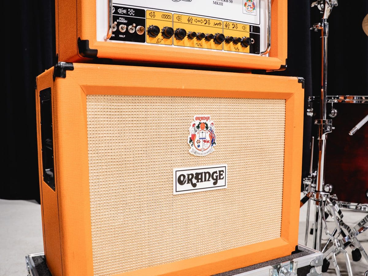 Orange amp stack beside a drum kit