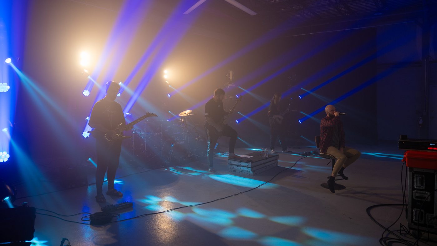 A band performing at Ruby Stage under full production lighting